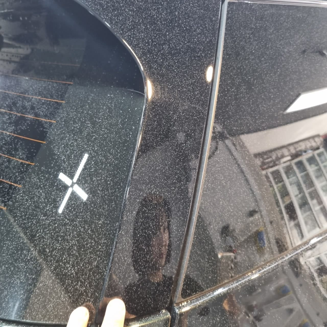 작업 전, 검정 차량 뒷유리 옆 도장면에 하얀 반점이 퍼져 있는 모습