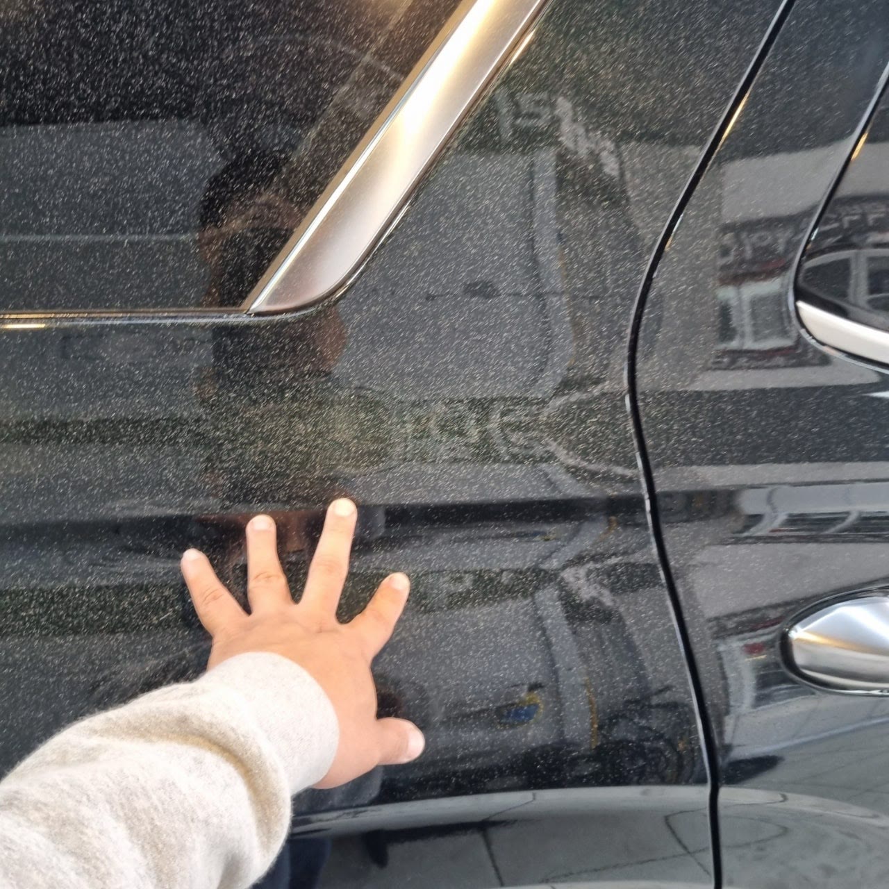 작업 전, 검정 SUV 뒷문 측면 도장면 전체에 하얀 반점이 있는 모습